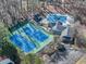 An aerial view of a house with tennis courts and a swimming pool, all surrounded by many trees at 3017 Lana Ln, Marietta, GA 30066