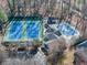A high angle view of a building with tennis courts and an inground pool, surrounded by trees at 3017 Lana Ln, Marietta, GA 30066