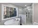 This bathroom features a modern soaking tub next to a glass enclosed shower and a view of the forest at 3017 Lana Ln, Marietta, GA 30066