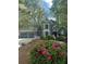 Charming two-story home with a three-car garage, landscaped yard, and blooming pink azaleas under a canopy of trees at 3017 Lana Ln, Marietta, GA 30066