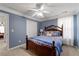 Inviting bedroom featuring a decorative bed frame, plush blue bedding, and natural light from the window at 3480 Arbroath Dr, Douglasville, GA 30135