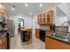Modern kitchen with wood cabinets, granite counters, and view into the dining area at 3480 Arbroath Dr, Douglasville, GA 30135