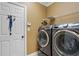 Well-organized laundry room with modern washer and dryer, storage shelf, and door at 3480 Arbroath Dr, Douglasville, GA 30135