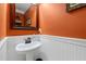 Charming powder room with pedestal sink, framed mirror, and wainscoting at 3480 Arbroath Dr, Douglasville, GA 30135