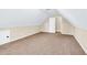This attic features carpeted floors, white ceiling, and a door leading to a storage space at 3865 Pointer Rd, Loganville, GA 30052