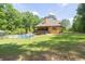 Backyard featuring in-ground pool, mature trees, and a well-maintained lawn and covered patio at 3865 Pointer Rd, Loganville, GA 30052