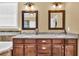 Well-lit bathroom with a double sink vanity, granite countertop, and decorative mirrors at 3865 Pointer Rd, Loganville, GA 30052