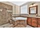 Elegant bathroom featuring a glass-enclosed shower and luxurious corner tub with stylish tile accents at 3865 Pointer Rd, Loganville, GA 30052