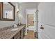 Modern bathroom with a granite countertop, dark cabinets, and a sleek mirror at 3865 Pointer Rd, Loganville, GA 30052
