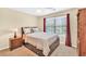 This carpeted bedroom features a window, ceiling fan, and a closet with storage on the side at 3865 Pointer Rd, Loganville, GA 30052