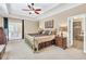 Bedroom featuring a tray ceiling, carpet flooring, and direct access to the ensuite bathroom at 3865 Pointer Rd, Loganville, GA 30052