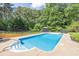 Refreshing backyard pool with steps and gazebo, surrounded by trees and greenery at 3865 Pointer Rd, Loganville, GA 30052