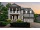 Elegant two-story home boasting a welcoming front porch, lush landscaping, and a spacious driveway at 4815 Westgate Drive, Cumming, GA 30040