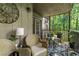 Charming covered porch with cozy seating, decorative rug, and serene views of the surrounding nature at 504 River Run Dr, Atlanta, GA 30350