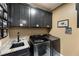 Functional laundry area with dark cabinets, stone countertop, and stainless steel appliances at 58 Canton St # 410, Alpharetta, GA 30009