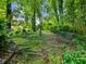 Secluded backyard garden with stone steps, garden decor and relaxing seating at 2910 Waverly Place Dr, Dacula, GA 30019