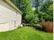Side view of a home's exterior showcasing the yard with lush landscaping and trees at 2910 Waverly Place Dr, Dacula, GA 30019