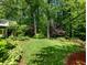 Lush backyard featuring green grass, mature trees, and well-maintained landscaping at 2910 Waverly Place Dr, Dacula, GA 30019