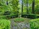 Backyard garden with stone benches, a statue, lush foliage, and a tranquil setting for relaxation and enjoyment at 2910 Waverly Place Dr, Dacula, GA 30019