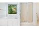 Clean bathroom with white tub shower and a frosted glass shower door next to a window at 2910 Waverly Place Dr, Dacula, GA 30019