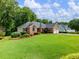 Well-maintained brick home featuring a lush green lawn and manicured landscaping at 2910 Waverly Place Dr, Dacula, GA 30019