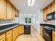 The kitchen features black appliances, wood cabinets, black countertops, and light wood floors at 2910 Waverly Place Dr, Dacula, GA 30019