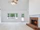 Spacious living room with a fireplace, ceiling fan, and a view of the backyard at 2910 Waverly Place Dr, Dacula, GA 30019