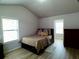Bedroom with a vaulted ceiling, two windows, neutral walls, and wood-look flooring at 3943 Ridge Grove Way, Suwanee, GA 30024