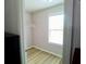 Walk-in closet featuring neutral walls, wood-look flooring, a single window, and a hanging rack at 3943 Ridge Grove Way, Suwanee, GA 30024