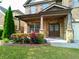 Charming front porch with stone columns, flowering plants, and a well-maintained lawn at 3943 Ridge Grove Way, Suwanee, GA 30024