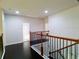 Hallway featuring dark wood floors and wrought iron railing, combining style and functionality at 3943 Ridge Grove Way, Suwanee, GA 30024