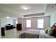 Main bedroom with a tray ceiling, light walls, wood-look floors, two large windows, and office area at 3943 Ridge Grove Way, Suwanee, GA 30024