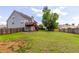Wide backyard with a patio, wood fence and green grass, creating an ideal space for outdoor living and entertainment at 535 Sugar Gate Ct, Lawrenceville, GA 30044