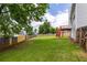 Large, grassy backyard with a wooden fence and deck, perfect for outdoor activities and relaxation at 535 Sugar Gate Ct, Lawrenceville, GA 30044