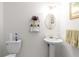 Bright bathroom features a pedestal sink, round mirror, and glass shelving for convenient storage and an airy feel at 535 Sugar Gate Ct, Lawrenceville, GA 30044