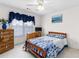 This cozy bedroom is staged with blue bedding and has window and dresser for natural light at 535 Sugar Gate Ct, Lawrenceville, GA 30044