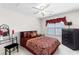 This cozy bedroom is staged with rich colors and has window and dresser natural light at 535 Sugar Gate Ct, Lawrenceville, GA 30044