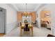 Dining area featuring a chandelier, tray ceiling, white wainscoting, and connection to the living room at 535 Sugar Gate Ct, Lawrenceville, GA 30044