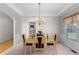 Chic dining room with elegant chandelier, wainscoting, neutral paint, and natural light from a window at 535 Sugar Gate Ct, Lawrenceville, GA 30044