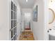 Hallway with hardwood floors leading to laundry, half bath, and garage access through a door at 535 Sugar Gate Ct, Lawrenceville, GA 30044