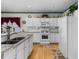 Functional kitchen equipped with white cabinetry, modern appliances, granite countertops, and hardwood floors at 535 Sugar Gate Ct, Lawrenceville, GA 30044