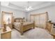 Well-lit main bedroom featuring a tray ceiling, plush bed, and wooden furnishings at 535 Sugar Gate Ct, Lawrenceville, GA 30044