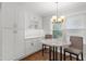 Bright breakfast nook features a marble table, seating for two, and custom cabinets for storage at 2221 Shallowford Rd, Marietta, GA 30066
