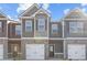 New townhome with gray siding, brick base, and a one-car garage, set under a bright blue sky at 225 Ivey Ter, Temple, GA 30179