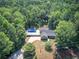 Aerial view of home with in-ground pool with a large concrete patio, and driveway surrounded by trees at 2652 Mount Tabor Church Rd, Dallas, GA 30157