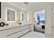 Modern bathroom with double sinks and a view to the bedroom and cityscape at 3107 Peachtree Ne Rd # 1005, Atlanta, GA 30305