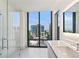 This bathroom has a glass shower with cityscape views that can be enjoyed from the vanity at 3107 Peachtree Ne Rd # 1005, Atlanta, GA 30305