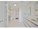 Bright bathroom featuring double vanities, a soaking tub, glass shower, and walk-in closet with custom shelving at 3107 Peachtree Ne Rd # 1005, Atlanta, GA 30305