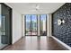Modern bedroom with dark wood floors, fan, geometric accent wall, and city views from large windows at 3107 Peachtree Ne Rd # 1005, Atlanta, GA 30305