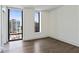 Modern bedroom with hardwood floors and cityscape views from large windows at 3107 Peachtree Ne Rd # 1005, Atlanta, GA 30305